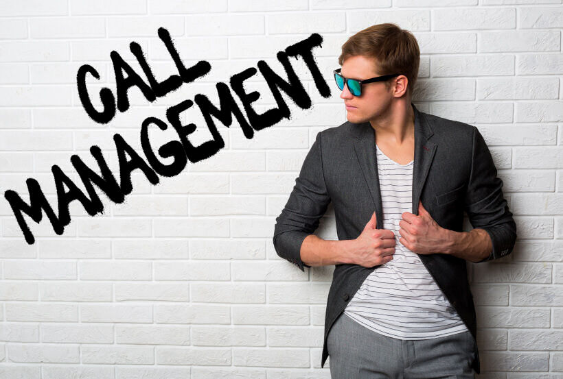 A business man in a suit leaning against a brick wall with the word call management written on it.